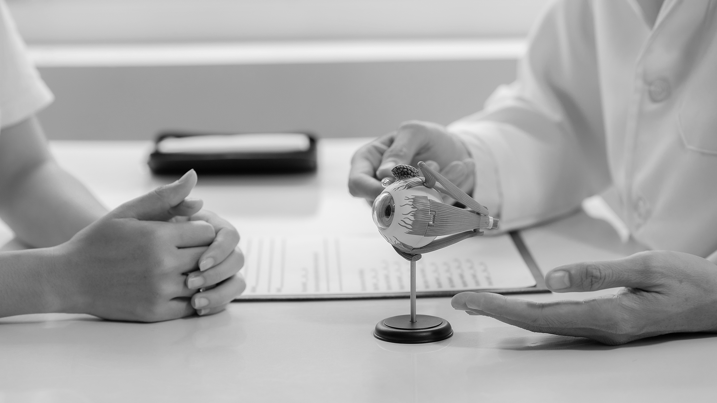 Okuvision: Arztgespräch – Hände von Patienten und Arzt auf dem Tisch
