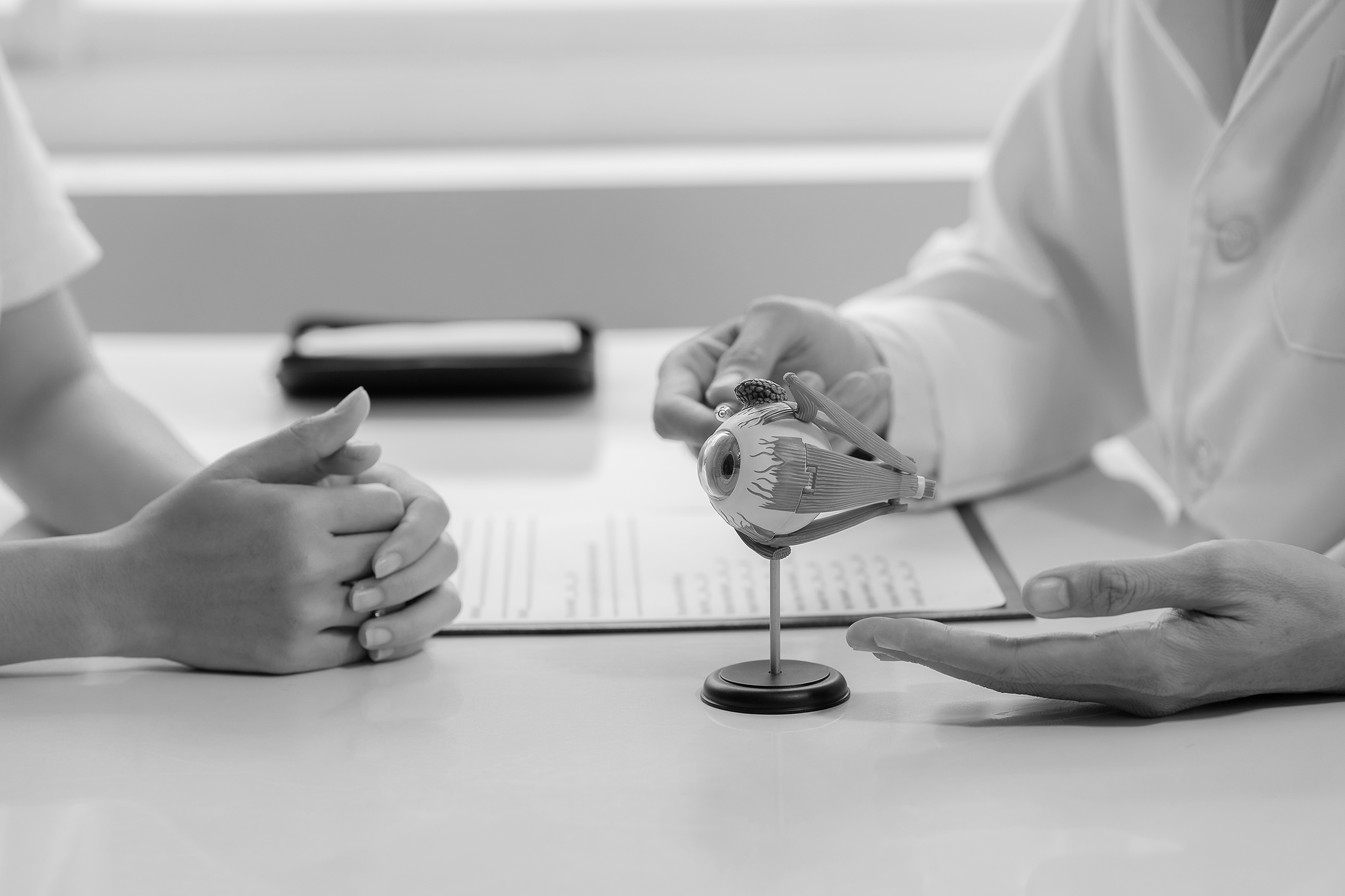 Okuvision: Arztgespräch – Hände von Patienten und Arzt auf dem Tisch
