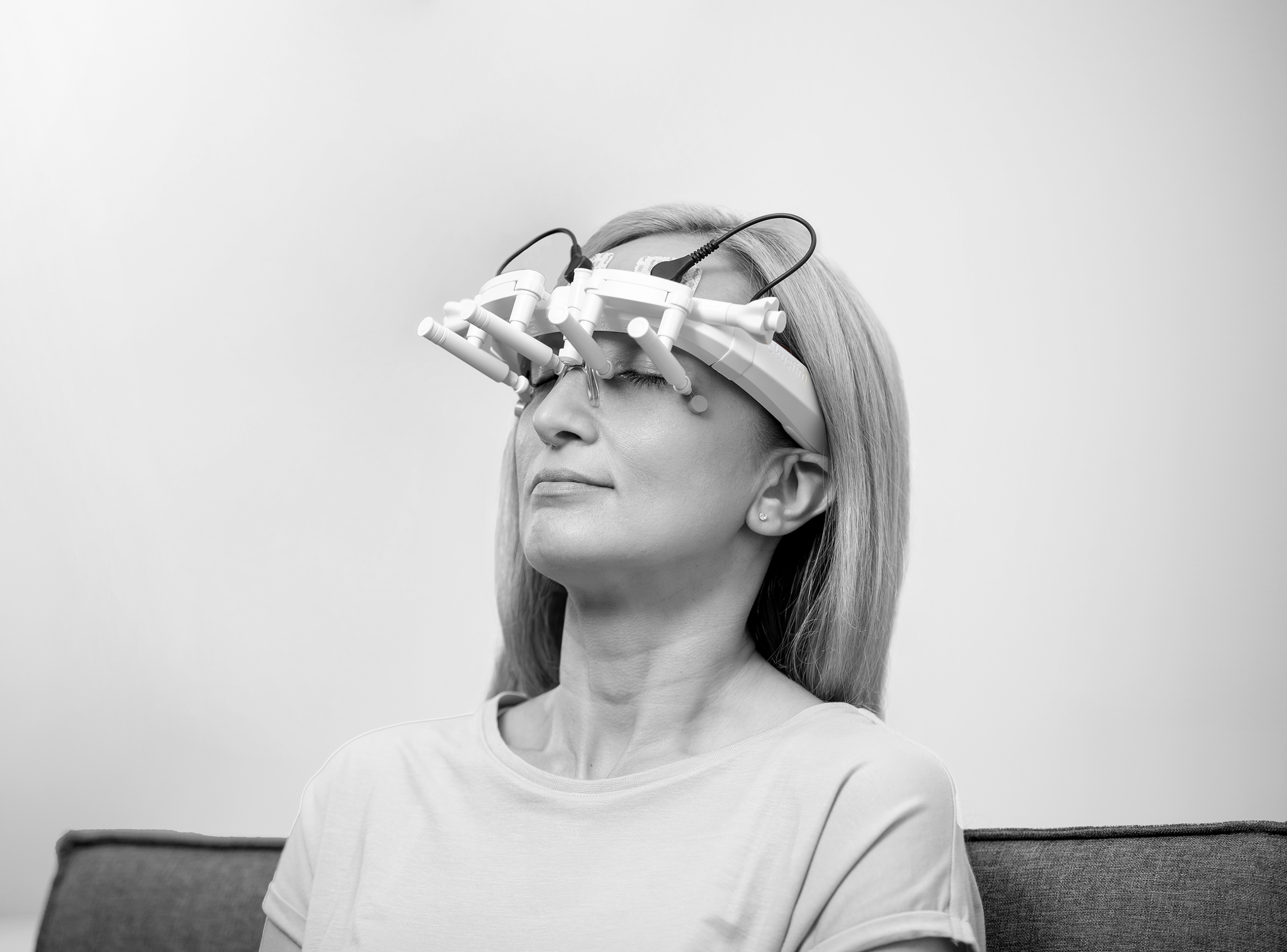 Junge Frau sitzend während OkuStim-Behandlung